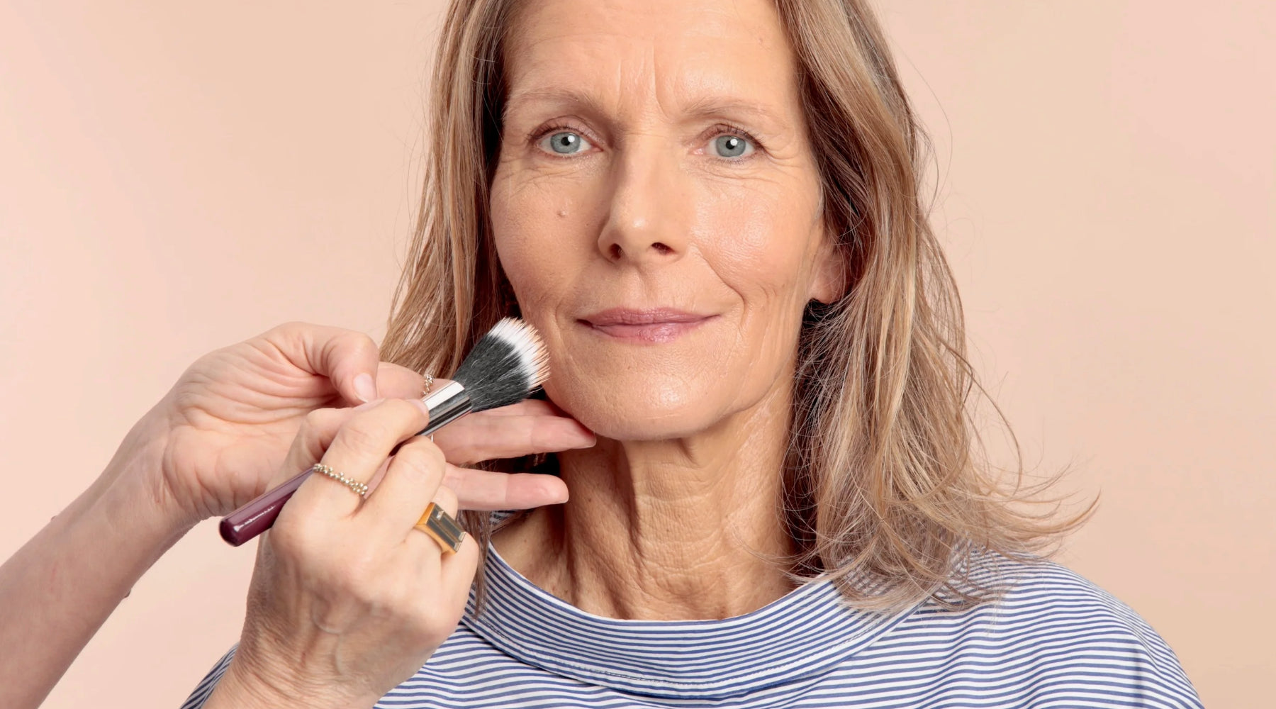 Une femme en train d'être maquillée avec un fond de teint qui ne contient pas de SPF